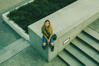 High angle view of woman sitting on staircase