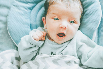 Portrait of baby girl lying on bed