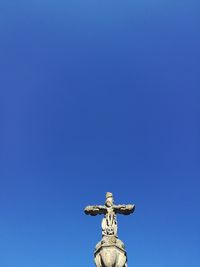 Low angle view of statue against clear blue sky