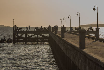 Pier on sea at sunset