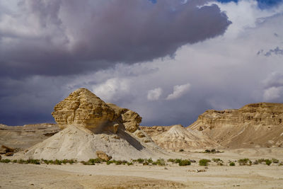 View of desert against cloudy stormy sky