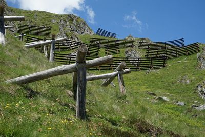 Wooden fence on field against sky