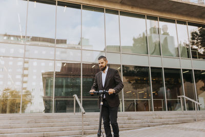 Businessman riding scooter