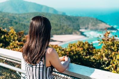 Rear view of woman sitting on mountain