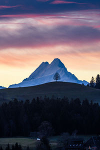 Scenic view of snowcapped mountains against sky at sunset