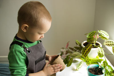 Cute boy holding table at home