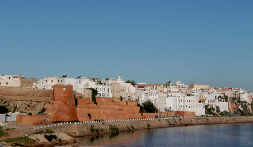 Buildings in town against clear blue sky