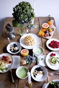 High angle view of various food on wooden table by wall