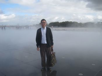 Portrait of man standing on tiled floor in fog