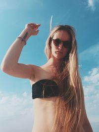 Low angle view of woman standing against clear sky