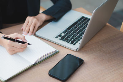 Midsection of man using laptop on table