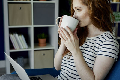 Midsection of woman holding coffee cup