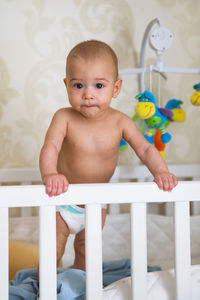 Portrait of cute baby boy sitting on railing
