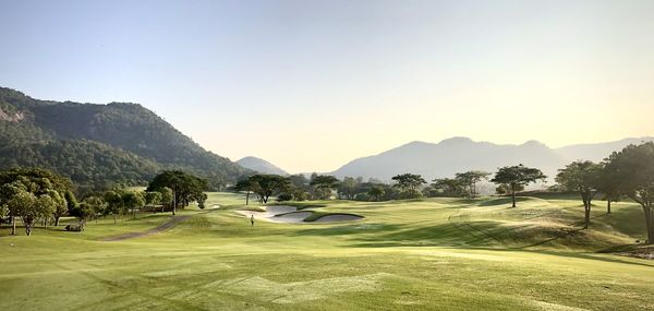 Scenic view of golf course against clear sky