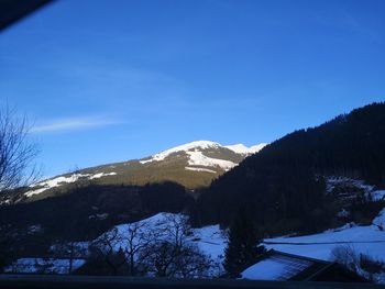 Scenic view of snowcapped mountains against blue sky