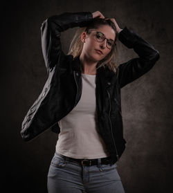 Young woman standing against black background