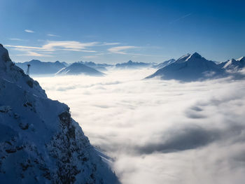 Scenic view of snowcapped mountains against blue sky