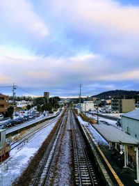 Railroad tracks against sky during winter