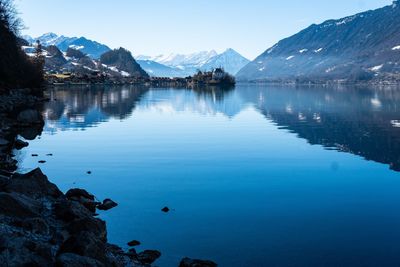 Scenic view of lake by mountains against sky