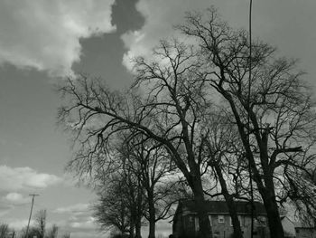 Low angle view of bare tree against cloudy sky