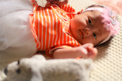 Portrait of cute baby lying on bed