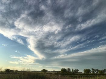 Scenic view of field against cloudy sky