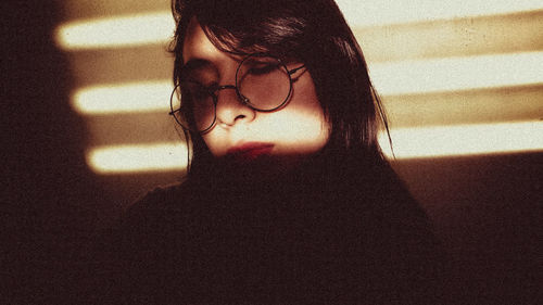 Close-up of woman wearing eyeglasses at home