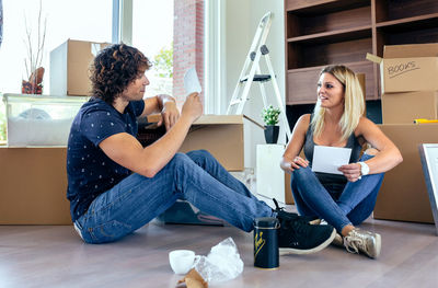 Happy young woman sitting on floor