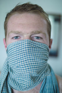 Close-up portrait of man covering face with scarf