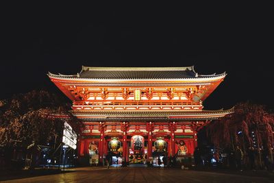 Low angle view of illuminated building against sky at night