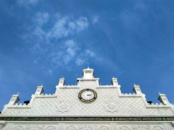 Low angle view of clock tower against blue sky