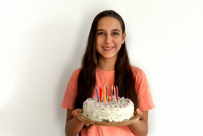 Portrait of smiling young woman against white background