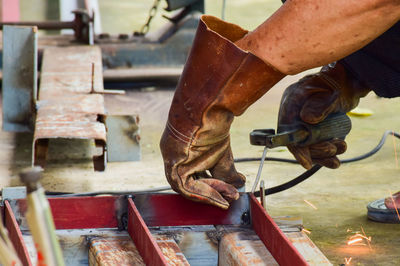 Low section of man working on metal