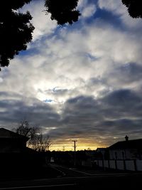 Silhouette of trees against cloudy sky
