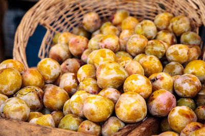 Organic emerald beaut plums in a basket sold at a farmers market and grown locally 