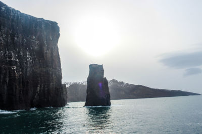 Rock formations by sea against sky