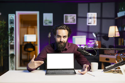 Portrait of young man using laptop at table