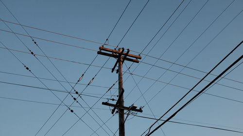 Low angle view of electricity pylon against sky