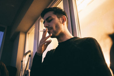 Man looking through window at home