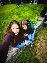 Portrait of smiling young woman sitting on field