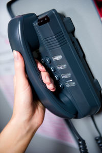 Cropped hand of woman holding telephone