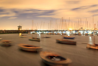 Boats moored on sea against sky during sunset