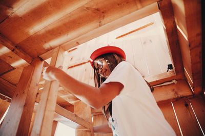 Low angle view of girl climbing wooden ladder in room