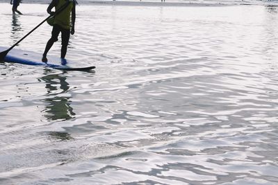 Low section of man standing in water