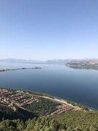 High angle view of sea and cityscape against clear sky