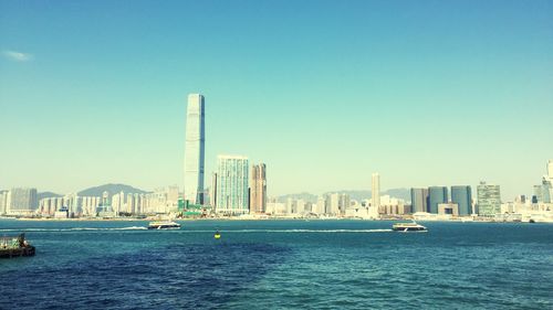 Boats sailing in sea against clear blue sky