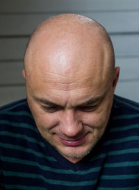 Close-up of smiling bald man at home