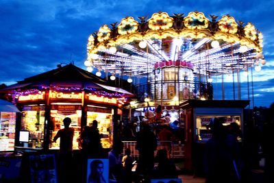 People at amusement park ride at night