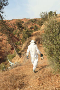 Rear view of man walking on field