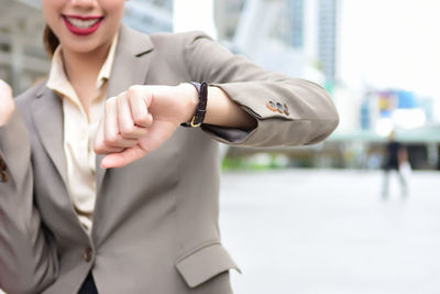 Midsection of businesswoman wearing wristwatch